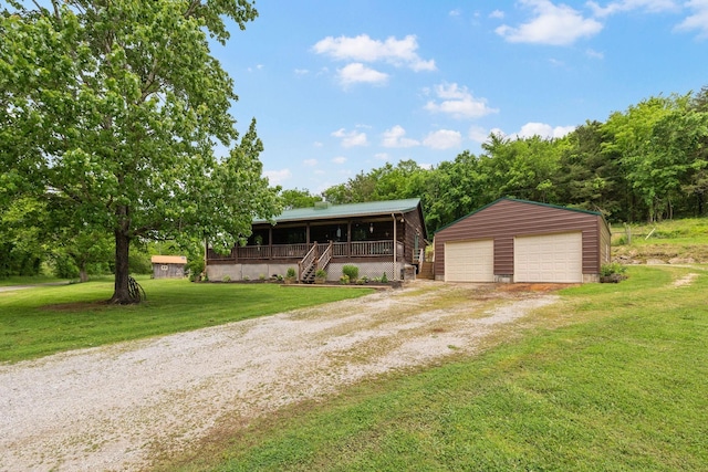 view of front of property featuring an outbuilding, a porch, a garage, driveway, and a front yard