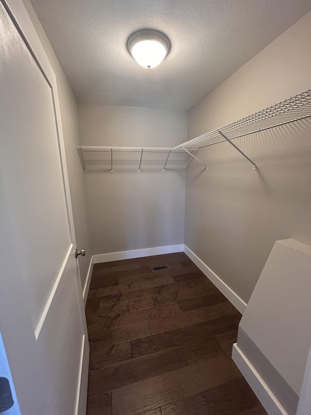 spacious closet featuring dark wood-style floors and visible vents