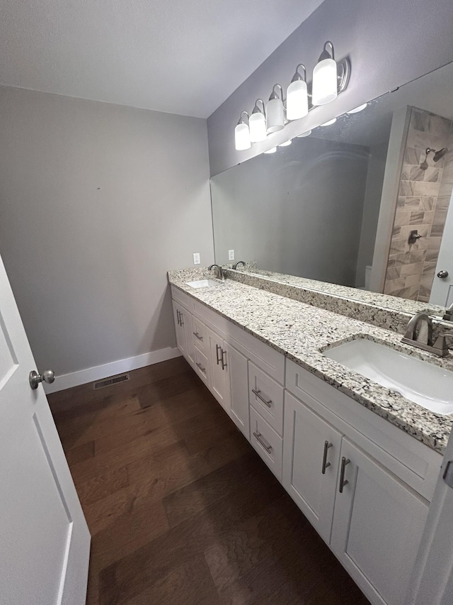 bathroom with visible vents, a sink, baseboards, and wood finished floors