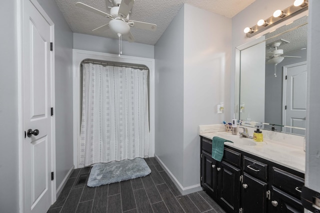 full bath featuring baseboards, ceiling fan, curtained shower, a textured ceiling, and vanity