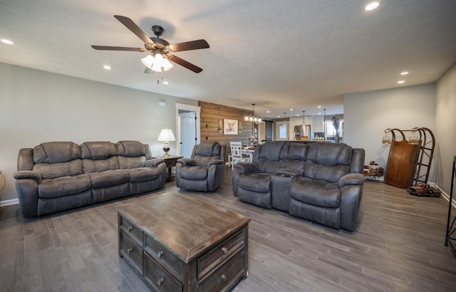 living area featuring wooden walls, a textured ceiling, wood finished floors, and recessed lighting