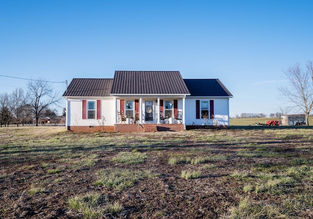 view of front of home with a porch, crawl space, metal roof, and a front lawn