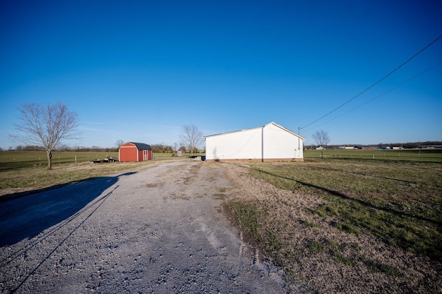 view of street with driveway and a rural view