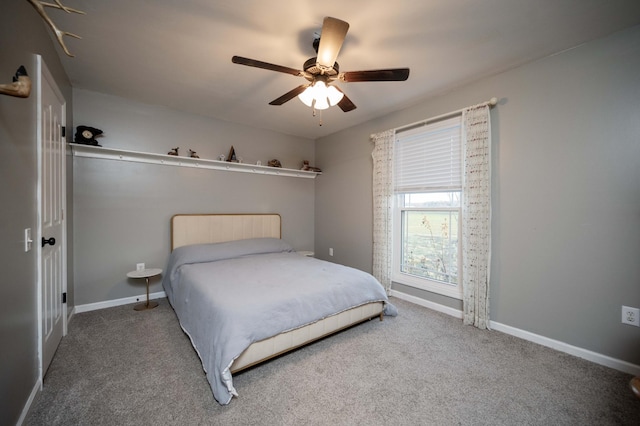 carpeted bedroom with ceiling fan and baseboards