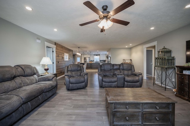 living area featuring recessed lighting, a textured ceiling, and wood finished floors