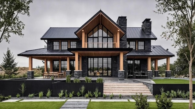 back of house with a standing seam roof, a porch, a chimney, stone siding, and metal roof