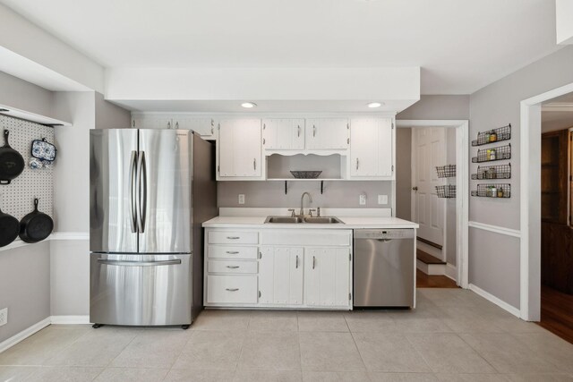 kitchen featuring stainless steel appliances, a sink, light countertops, and white cabinets