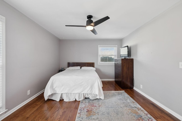 bedroom with ceiling fan, wood finished floors, and baseboards