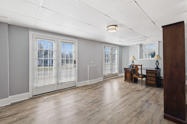 home office with a wealth of natural light, a paneled ceiling, and wood finished floors