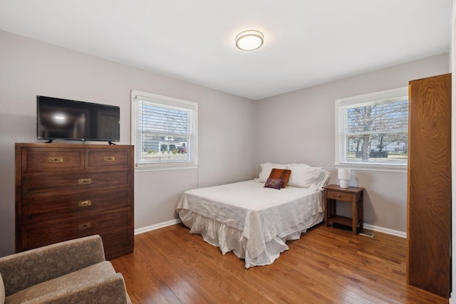 bedroom featuring hardwood / wood-style flooring and baseboards