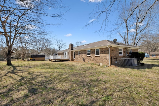 back of property featuring an outbuilding, brick siding, fence, a yard, and a storage unit