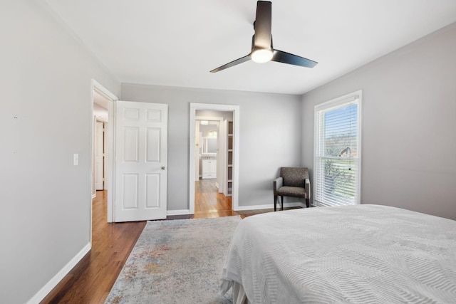 bedroom featuring ceiling fan, wood finished floors, connected bathroom, and baseboards