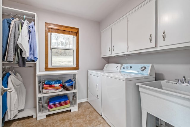 washroom with light tile patterned flooring, a sink, baseboards, cabinet space, and washer and clothes dryer