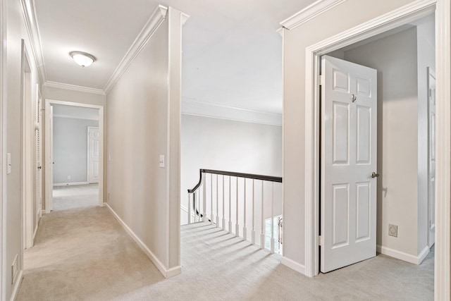 hallway featuring carpet floors, crown molding, and an upstairs landing