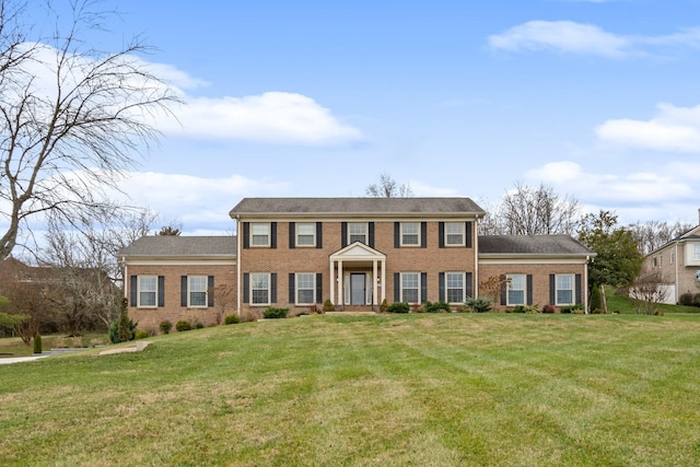 colonial house with brick siding and a front yard