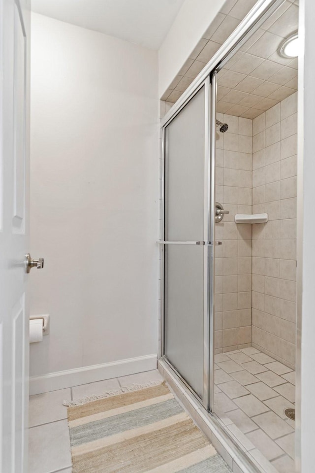 bathroom with a stall shower and baseboards