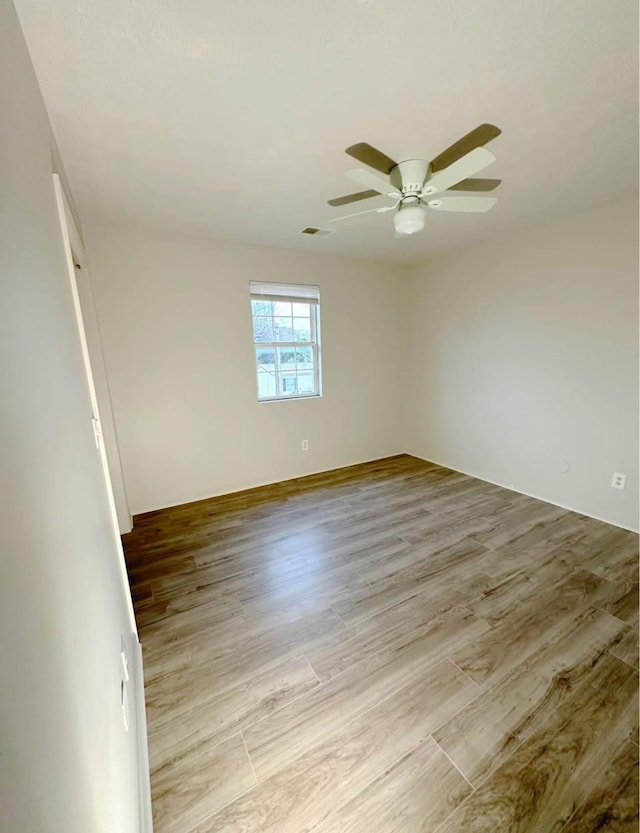 unfurnished room with a ceiling fan, light wood-type flooring, and visible vents