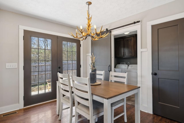 dining space featuring french doors, dark wood-type flooring, washer and clothes dryer, and visible vents