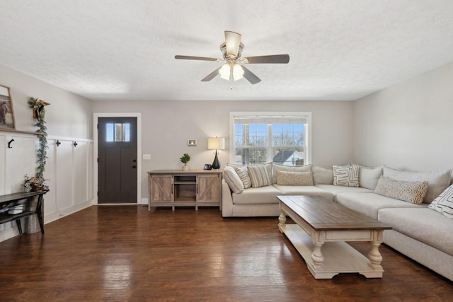 living area with a ceiling fan, a textured ceiling, and wood finished floors