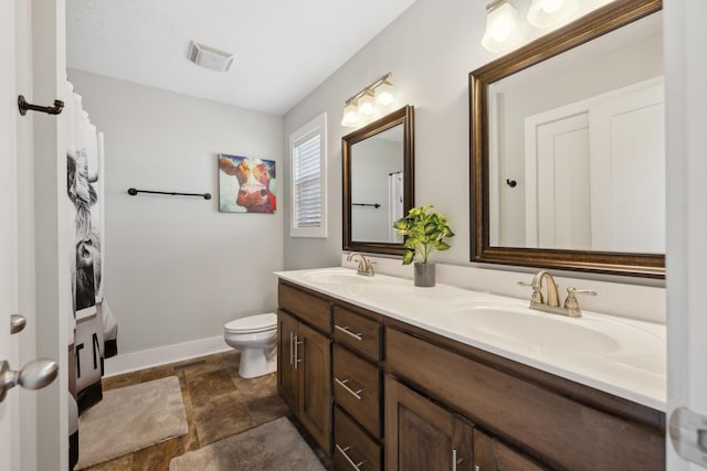 full bathroom featuring toilet, double vanity, visible vents, and a sink