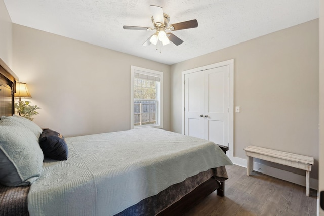 bedroom featuring a closet, ceiling fan, a textured ceiling, and wood finished floors