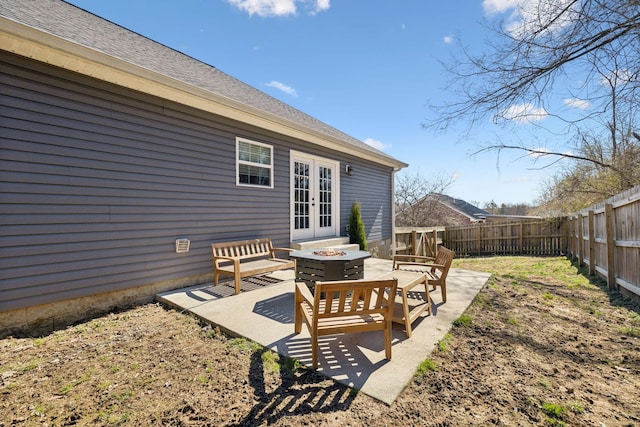 exterior space with a fire pit, french doors, and a fenced backyard