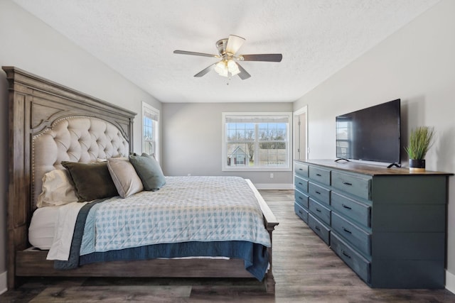 bedroom with ceiling fan, a textured ceiling, baseboards, and wood finished floors