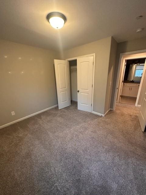 unfurnished bedroom with carpet, a closet, and baseboards