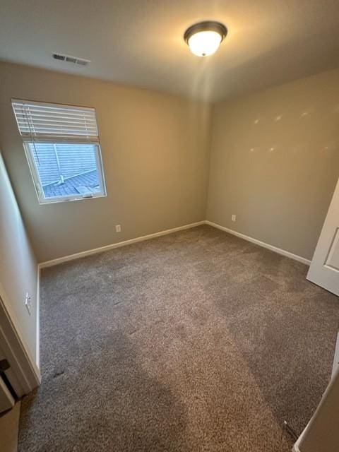 carpeted spare room with visible vents and baseboards