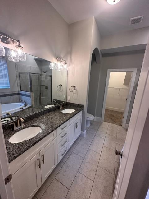 full bath with a stall shower, a sink, visible vents, and tile patterned floors