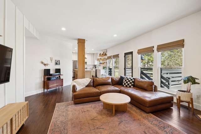 living area featuring dark wood-style floors, decorative columns, and recessed lighting