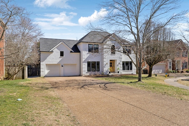 french country style house with a garage, fence, driveway, and a front lawn