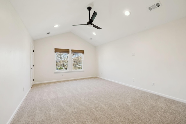 spare room with baseboards, visible vents, a ceiling fan, light colored carpet, and lofted ceiling