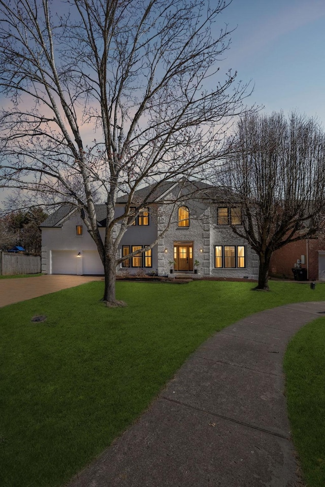 view of front of property featuring concrete driveway and a front lawn