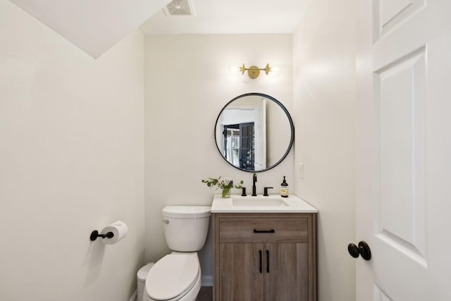 half bathroom featuring toilet, visible vents, and vanity