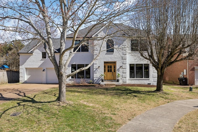 colonial-style house featuring a front yard, crawl space, brick siding, and driveway