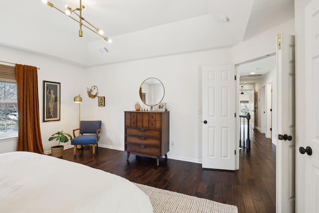 bedroom with lofted ceiling, wood finished floors, visible vents, and baseboards