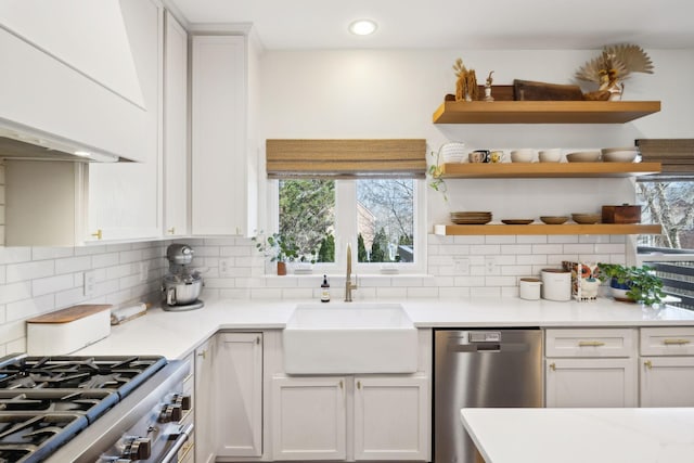 kitchen with decorative backsplash, stainless steel appliances, white cabinetry, a sink, and recessed lighting