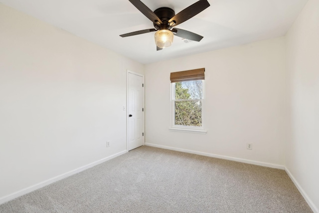 spare room with light carpet, ceiling fan, and baseboards