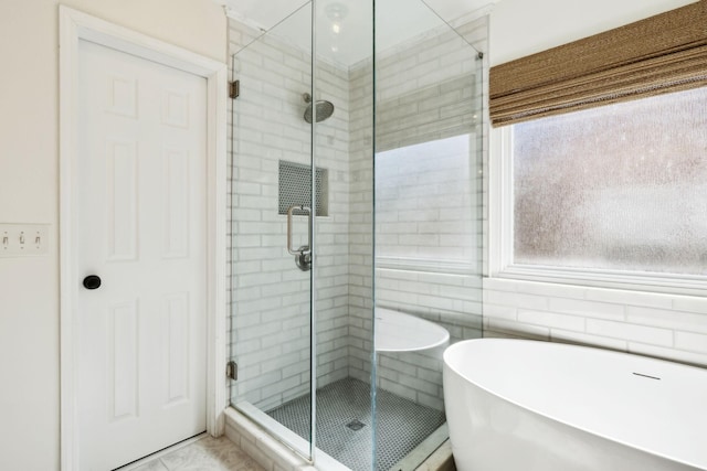 full bath featuring a soaking tub and a shower stall