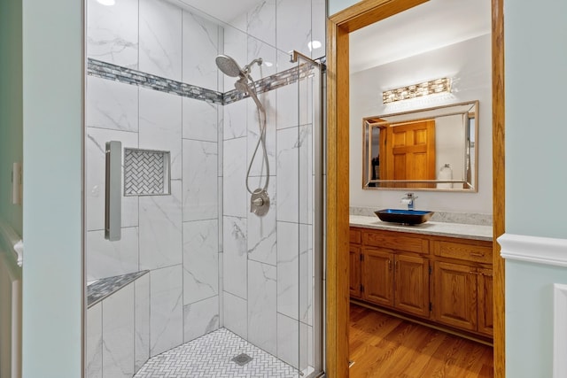 full bath featuring a stall shower, vanity, and wood finished floors