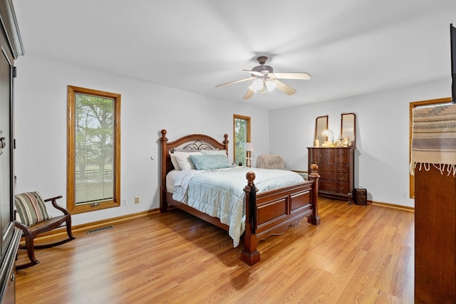 bedroom featuring light wood finished floors, baseboards, visible vents, and ceiling fan