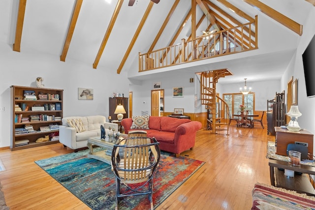 living room with hardwood / wood-style flooring, stairway, beamed ceiling, high vaulted ceiling, and ceiling fan with notable chandelier