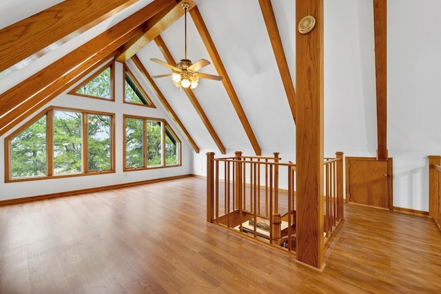 additional living space featuring vaulted ceiling with beams, wood finished floors, and baseboards