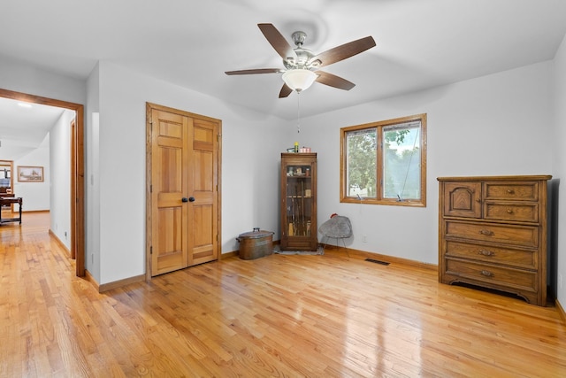 unfurnished bedroom with light wood-style floors, baseboards, visible vents, and a ceiling fan