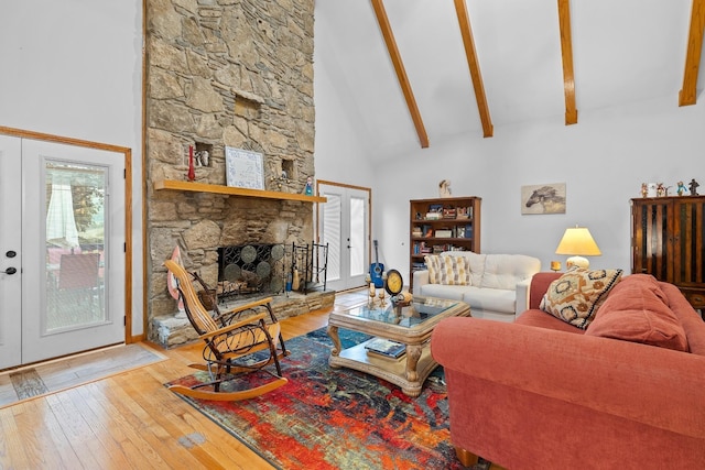 living area featuring high vaulted ceiling, wood-type flooring, a fireplace, and beam ceiling