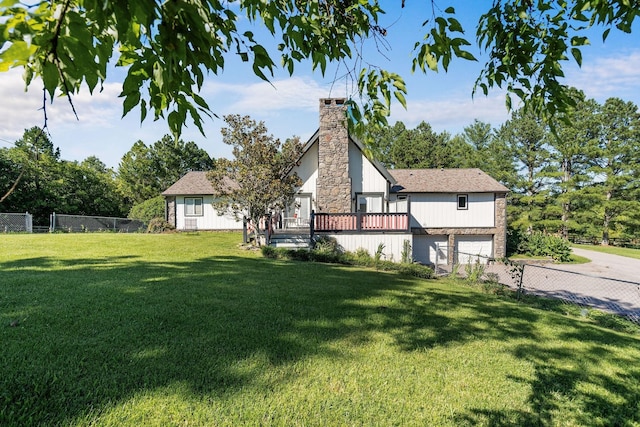 view of side of property featuring a garage, driveway, a lawn, a chimney, and fence