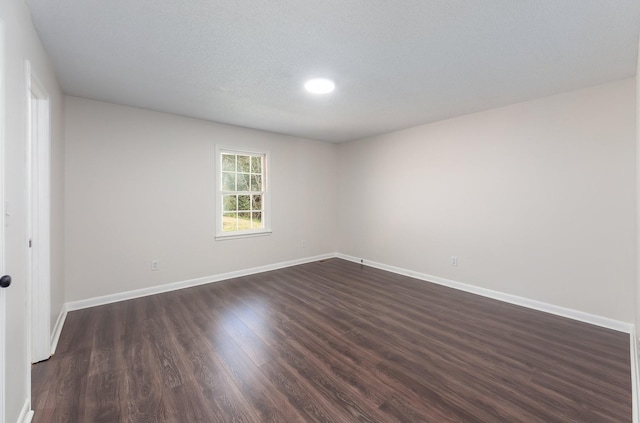 empty room with baseboards and dark wood-style flooring