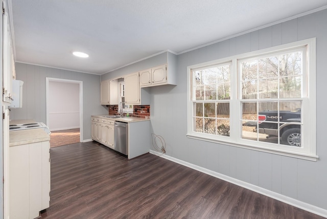 kitchen featuring a healthy amount of sunlight, ornamental molding, light countertops, and dark wood finished floors