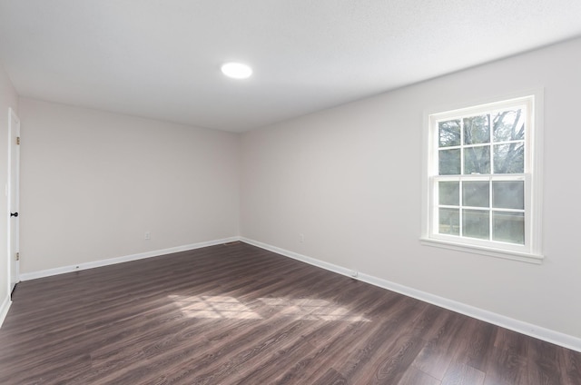 unfurnished room featuring dark wood finished floors and baseboards